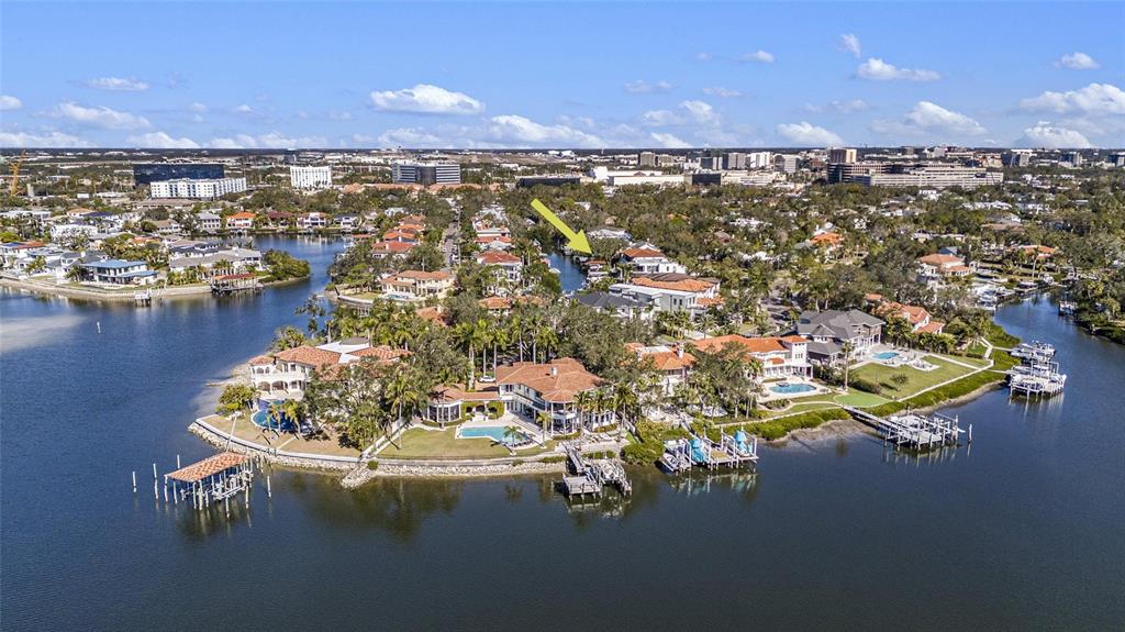 An aerial view shows luxury waterfront homes with private docks along a canal — 5123 W NEPTUNE WAY, TAMPA, FL