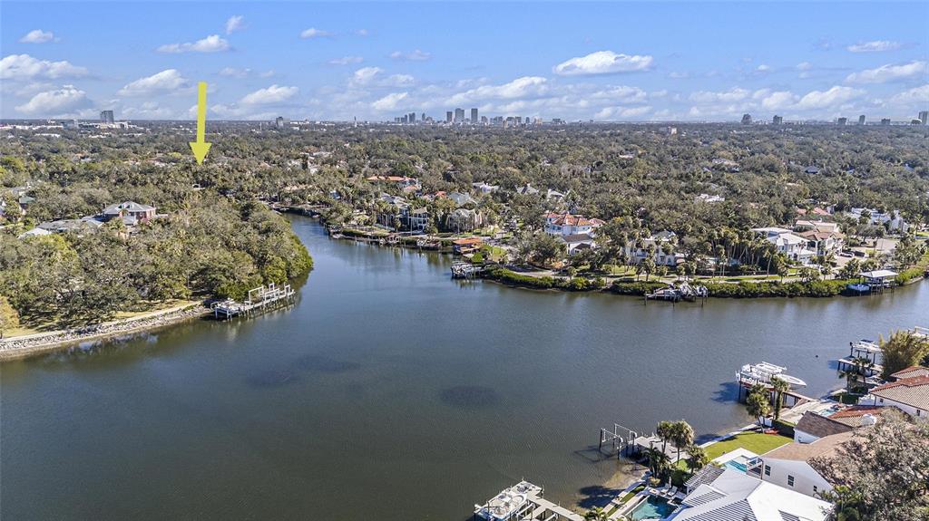 An aerial view shows a winding river surrounded by dense trees and residential waterfront properties — 5123 W NEPTUNE WAY, TAMPA, FL