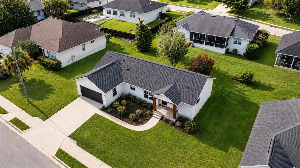 An aerial view shows a single-story white house with a dark roof and attached garage — 11348 NW 31ST LANE, GAINESVILLE, FL