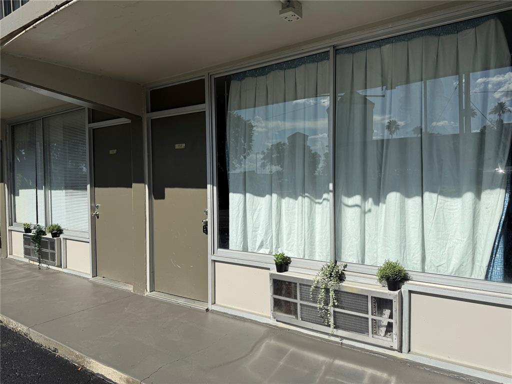 Exterior view of a motel-style building with two doors, large windows, and air conditioning units — 5020 W IRLO BRONSON MEMORIAL HIGHWAY UNIT 262, KISSIMMEE, FL