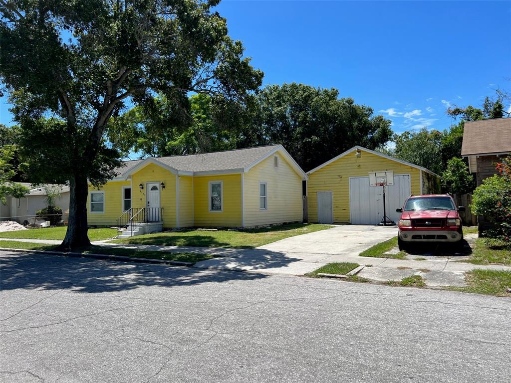 A yellow house with a detached garage and a red truck parked in the driveway — 2734 53RD AVENUE N, ST PETERSBURG, FL