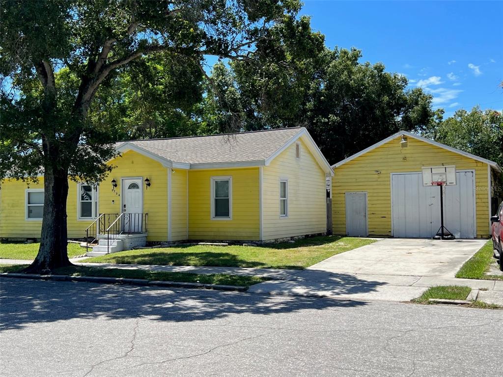A yellow house with a detached garage and a basketball hoop on a concrete driveway — 2734 53RD AVENUE N, ST PETERSBURG, FL