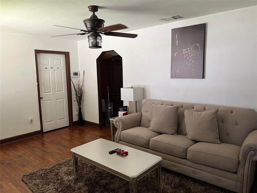 A living room features a beige sofa, a coffee table, and a ceiling fan — 2734 53RD AVENUE N, ST PETERSBURG, FL