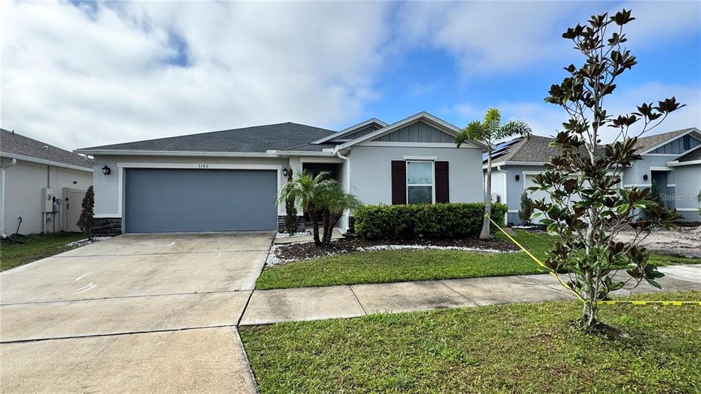 A single-story suburban house with a gray garage, light-colored siding, and a front lawn — 3182 EAGLE HAMMOCK CIRCLE, KISSIMMEE, FL