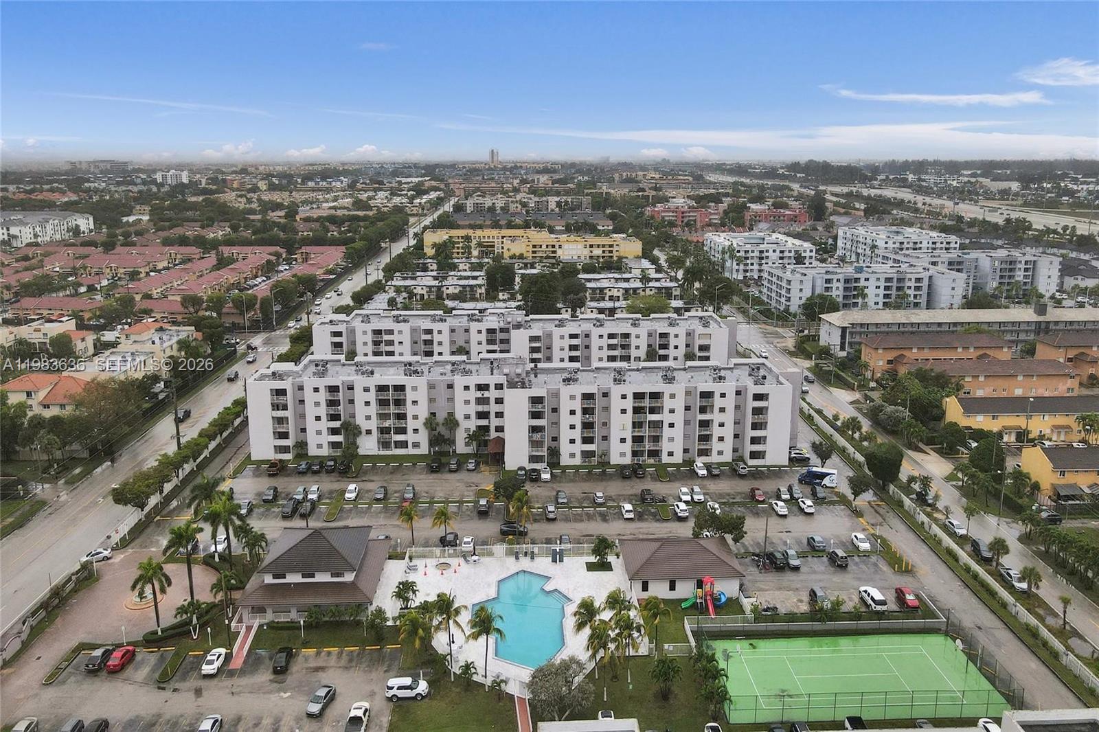 An aerial view shows a multi-story apartment complex with a swimming pool and tennis court — 8145 NW 7th St # 315, Miami FL 33126, MIAMI, FL
