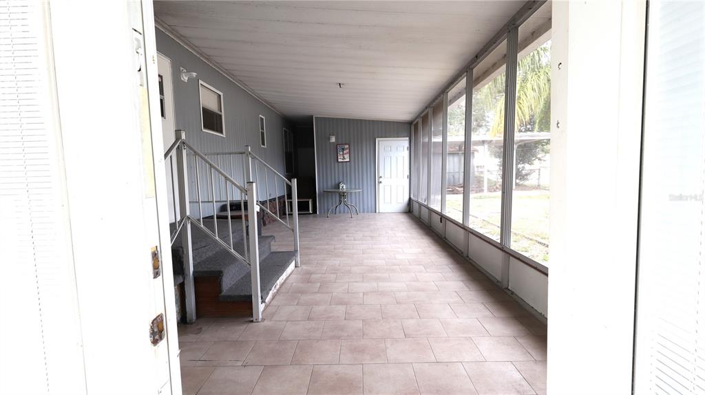 A gray mobile home features a covered porch with metal railings and a large yucca plant — 1158 CR 439, LAKE PANASOFFKEE, FL