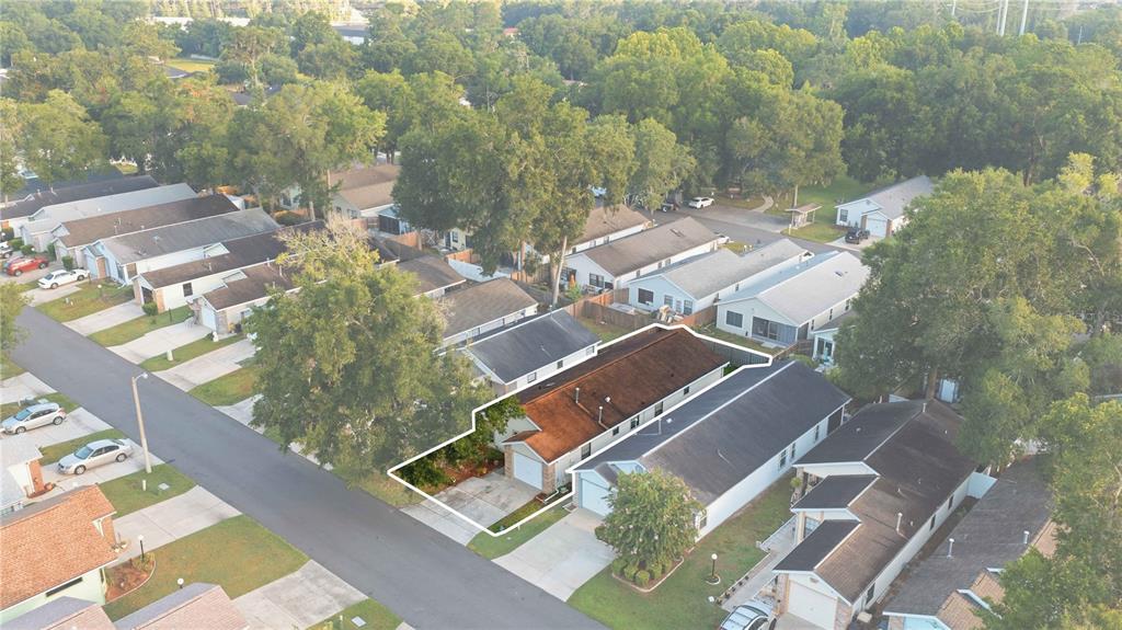 An aerial view shows a single-story suburban house with a brown roof and a driveway — 3925 NE 22ND STREET, OCALA, FL