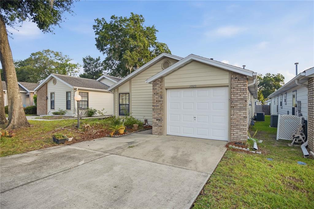 A single-story house with light siding, a brick facade, and a one-car garage — 3925 NE 22ND STREET, OCALA, FL