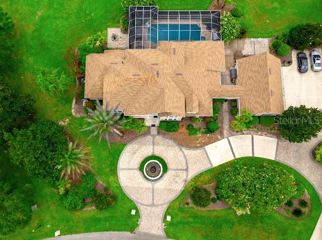 An aerial view shows a house with a pool enclosure, circular driveway, and surrounding lawn — 6823 NW 52ND LANE, GAINESVILLE, FL