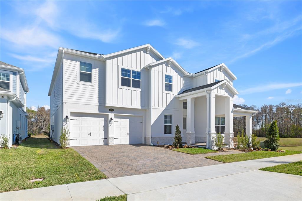 A two-story white house with a two-car garage and a covered front porch — 16788 MUSKGRASS DRIVE, WINTER GARDEN, FL