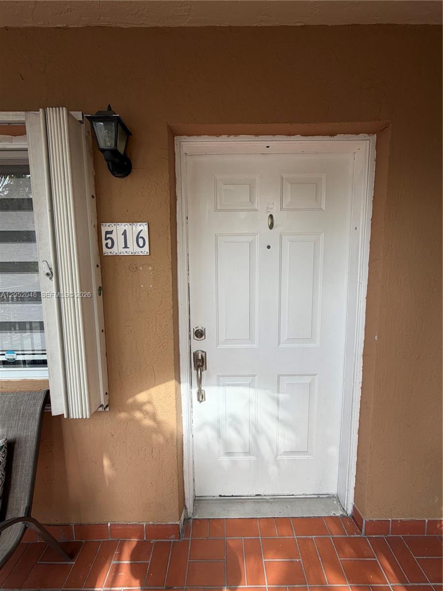 A white front door with the number 516 is set in a tan exterior wall — 551 NW 82nd Ave # 516, Miami FL 33126, MIAMI, FL
