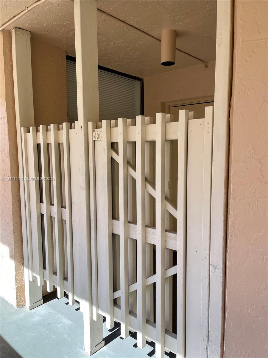 A white wooden gate with the number 408 stands on a covered outdoor walkway — 6800 Cypress Rd # 408, Plantation FL 33317, PLANTATION, FL