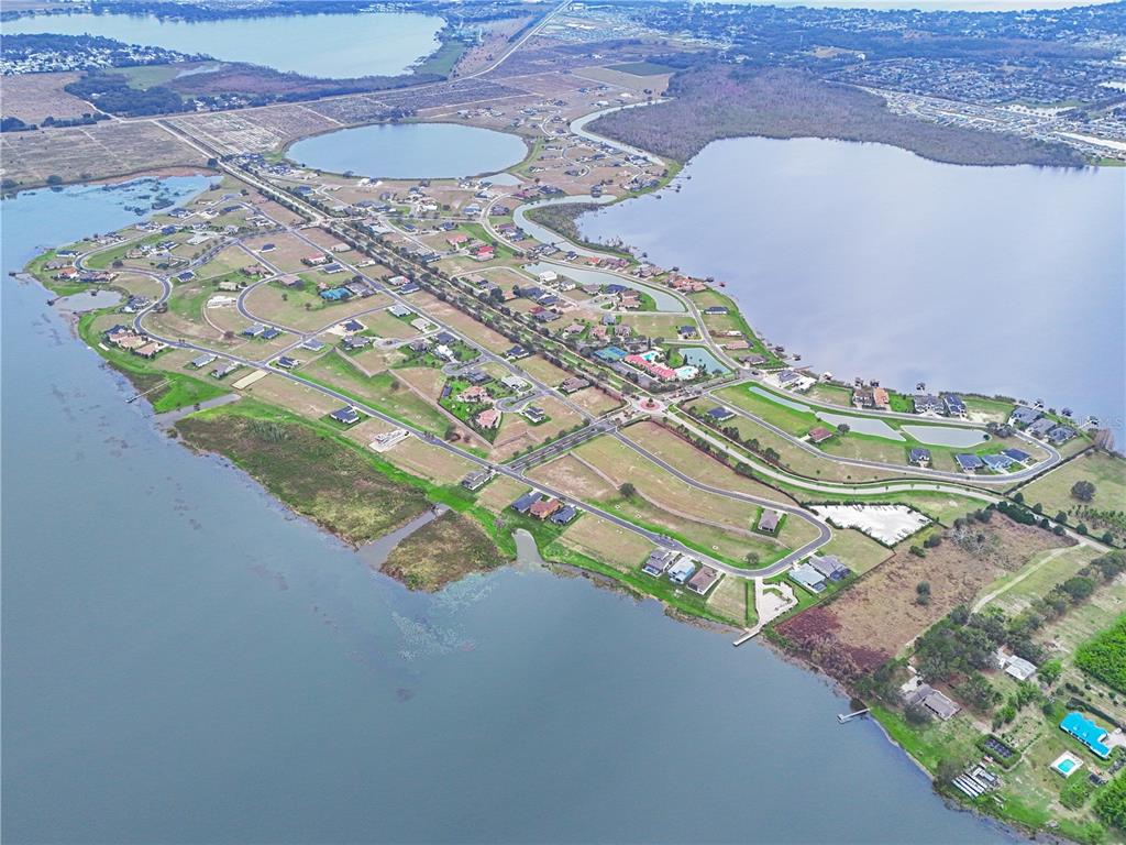 An aerial view shows a residential neighborhood situated on a peninsula surrounded by large lakes — 429 ADAMS VIEW LANE, AUBURNDALE, FL