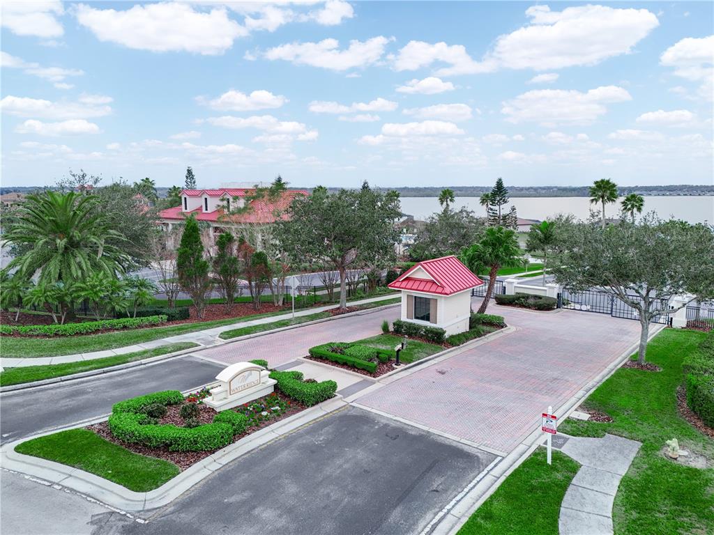An aerial view shows the gated entrance of a residential community with a guardhouse — 429 ADAMS VIEW LANE, AUBURNDALE, FL