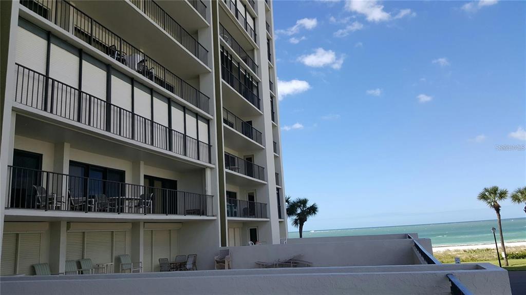 A multi-story residential building with balconies overlooking a beach and the ocean — 1480 GULF BOULEVARD UNIT 106, CLEARWATER BEACH, FL