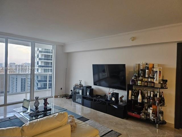 A living room features a television, a bar cart, and floor-to-ceiling windows with city views — 1830 S Ocean Dr # 2403, Hallandale Beach FL 33009, HALLANDALE BEACH, FL