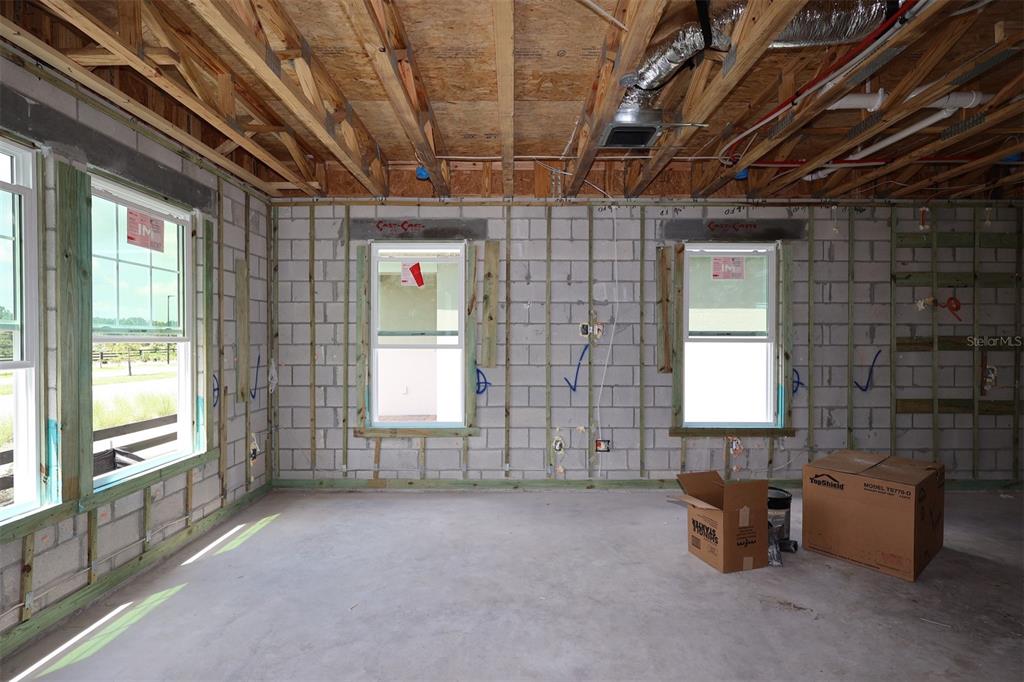 An unfinished interior space features exposed wood framing, concrete block walls, and ceiling trusses — 5294 CENTER LAKE RANCH BOULEVARD, ST CLOUD, FL