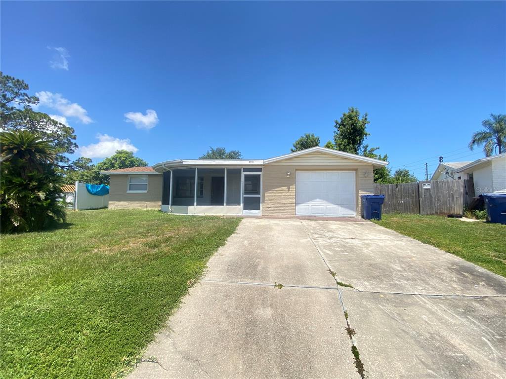 A single-story house with a screened-in porch, a one-car garage, and a concrete driveway — 2713 CAPRICORN PLACE, HOLIDAY, FL