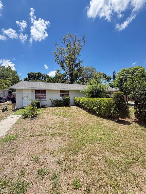 A single-story house with a white exterior, a gray shingled roof, and a manicured hedge — 4212 9TH STREET E, BRADENTON, FL