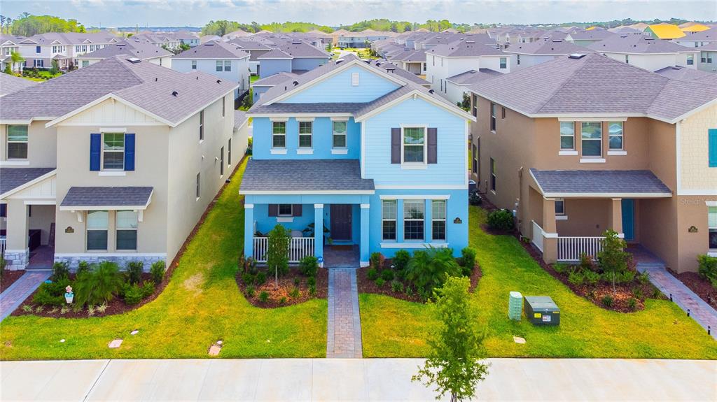 An aerial view shows a light blue two-story house between two other suburban homes — 16596 POINT ROCK DRIVE, WINTER GARDEN, FL