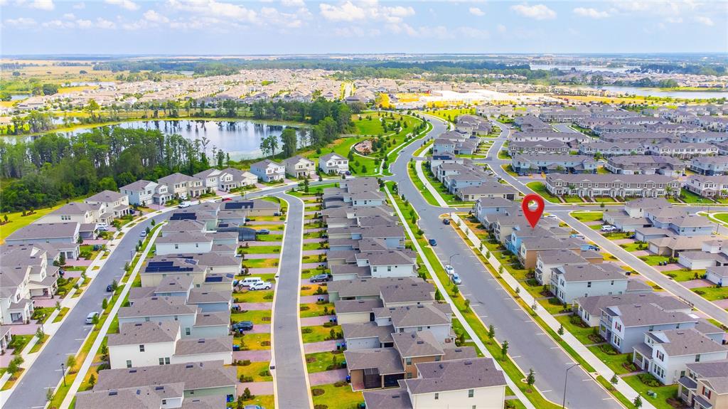 An aerial view of a suburban neighborhood featuring numerous houses, a lake, and roads — 16596 POINT ROCK DRIVE, WINTER GARDEN, FL