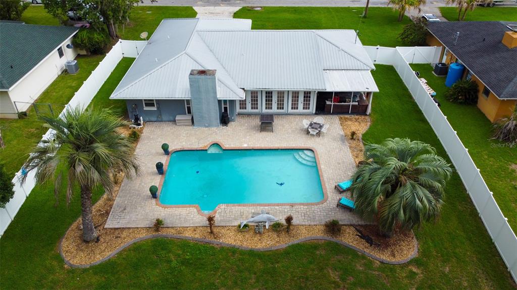 An aerial view shows a house with a metal roof, swimming pool, and fenced yard — 5072 SE 27TH STREET, OCALA, FL