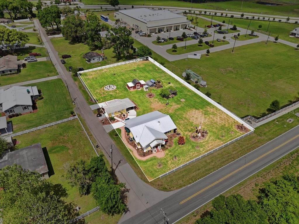 An aerial view shows a fenced residential property with two houses, a barn, and landscaping — 4225 OLD KATHLEEN ROAD, LAKELAND, FL