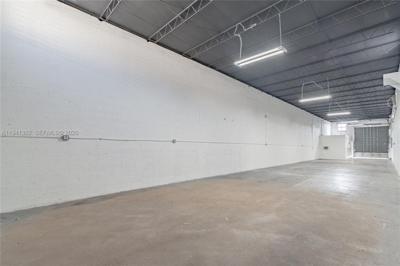 An empty industrial warehouse space features white concrete walls, a gray ceiling, and concrete flooring — 569 W 28th St, Hialeah FL 33010, HIALEAH, FL
