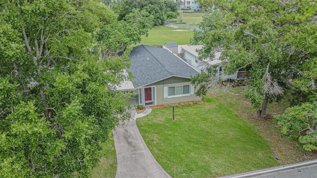 An aerial view of a single-story house with a gray roof, green siding, and driveway — 925 CEDARWOOD AVENUE, DUNEDIN, FL