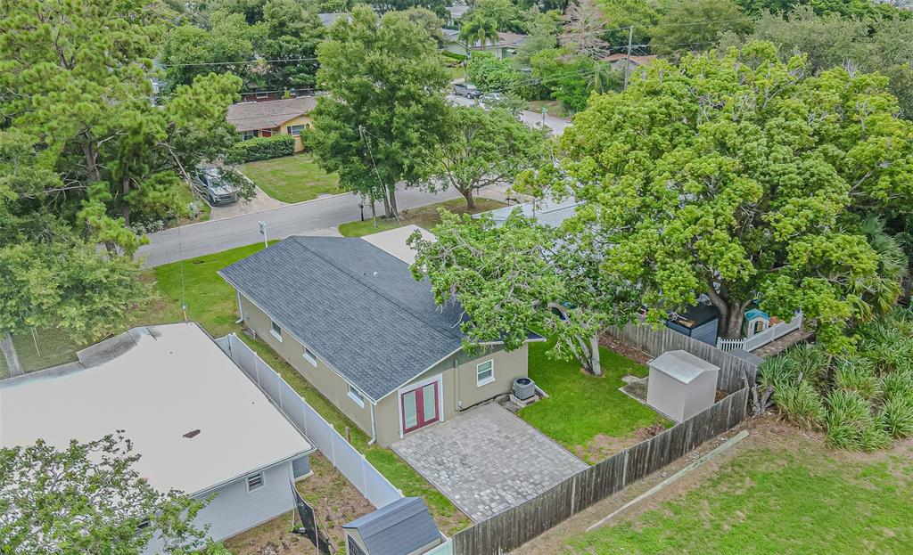 An aerial view of a house with a gray roof, brick patio, and fenced backyard — 925 CEDARWOOD AVENUE, DUNEDIN, FL