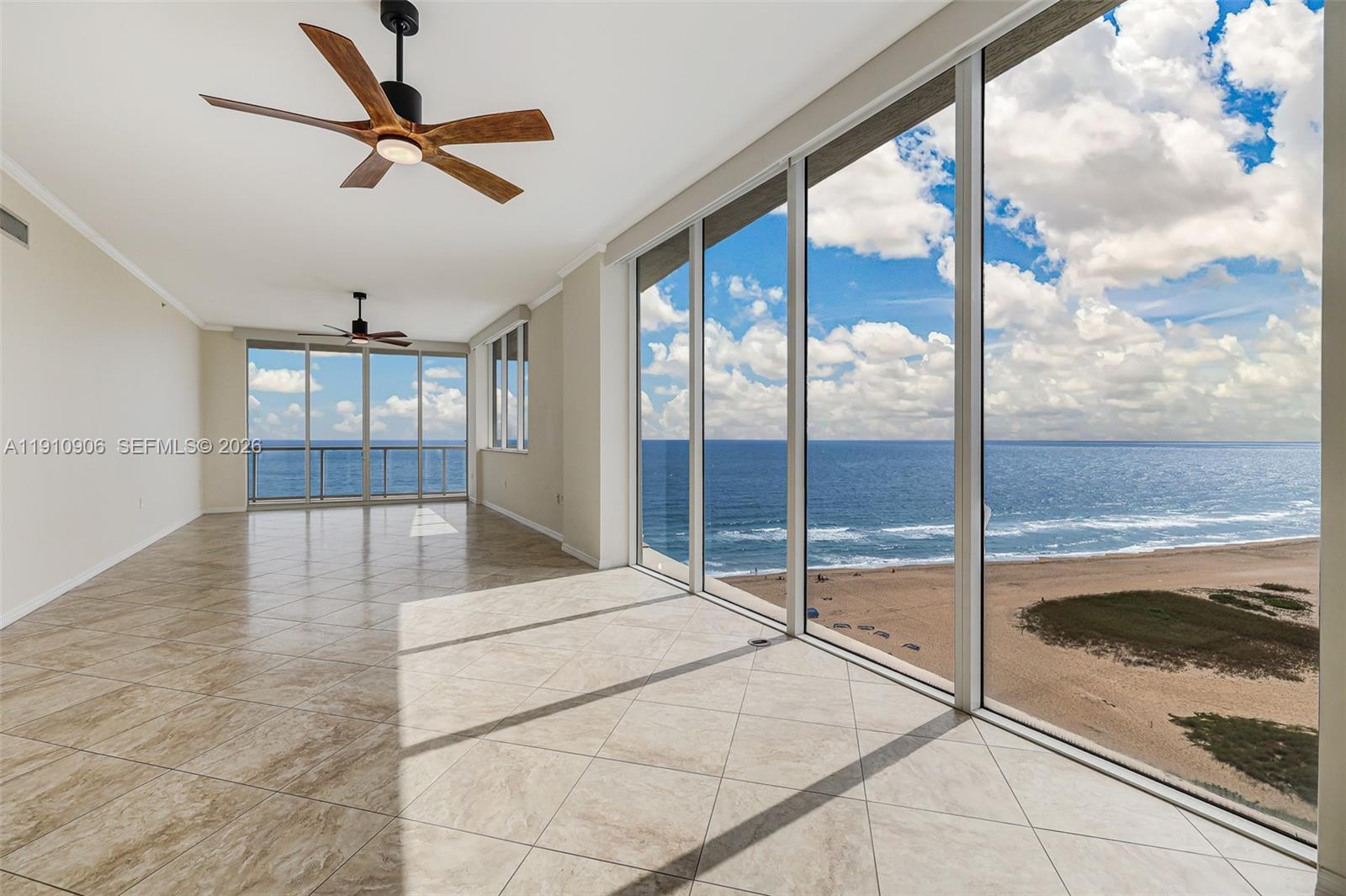 An empty room with tiled floors and floor-to-ceiling windows overlooking the ocean and beach — 704 N Ocean Blvd # 1001, Pompano Beach FL 33062, POMPANO BEACH, FL