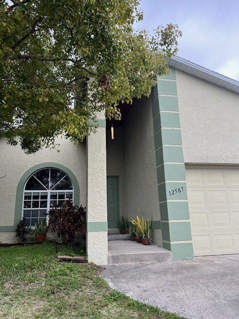 The exterior of a two-story house features a green-trimmed arched window and a garage — 12587 PARK BOULEVARD, SEMINOLE, FL