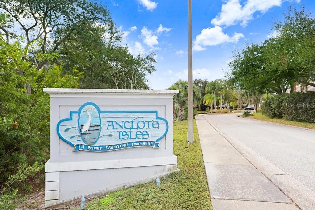 A sign for the Anclote Isles waterfront community stands beside a paved residential street — 1161 MARINA DRIVE, TARPON SPRINGS, FL