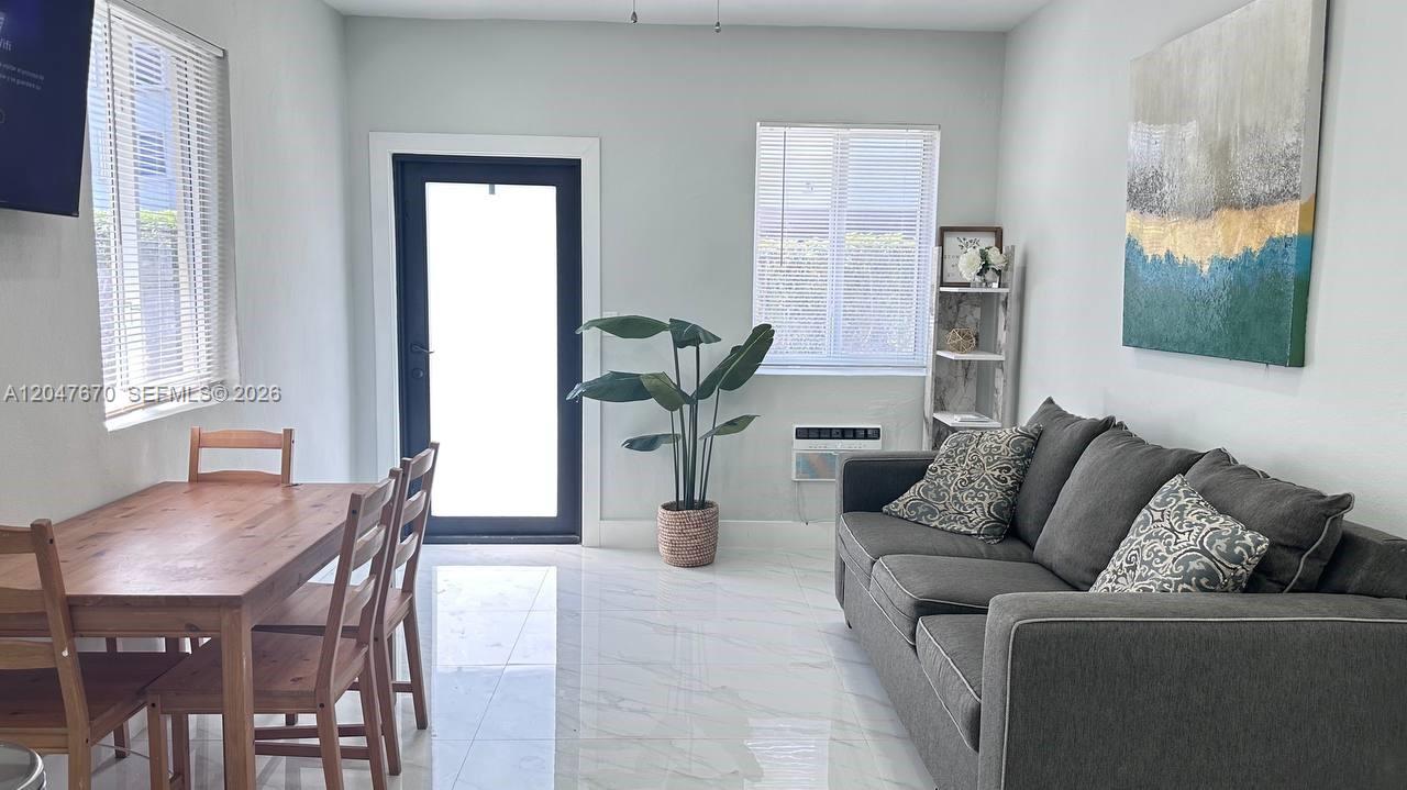 A living and dining area features white tile floors, a gray sofa, and a wooden table — 320 SW 29th Rd, Miami FL 33129, MIAMI, FL