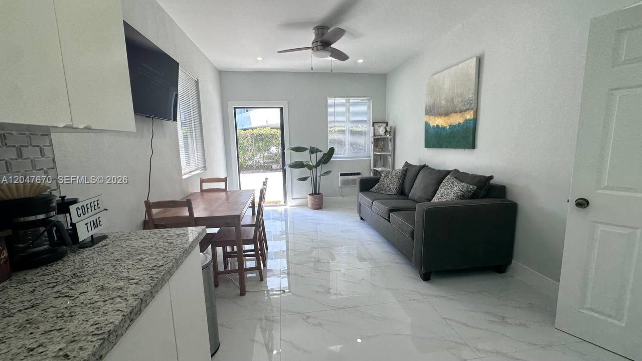 A living room features a grey sofa, dining table, and white tile flooring — 320 SW 29th Rd, Miami FL 33129, MIAMI, FL
