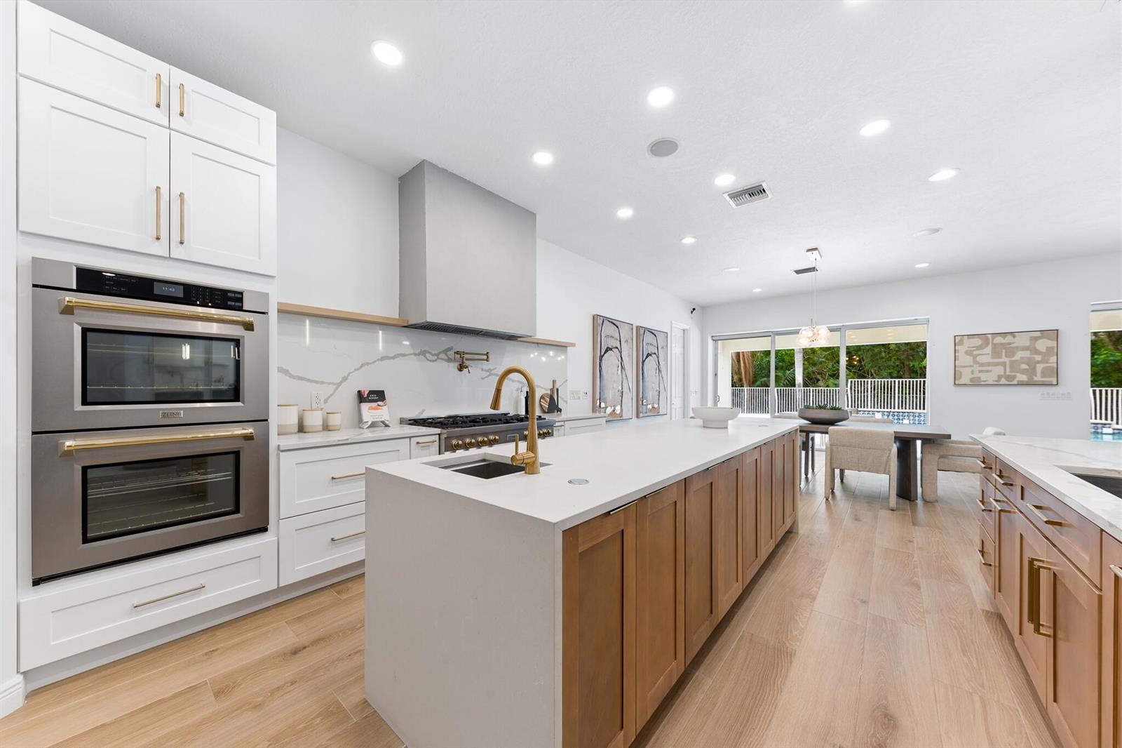 A bright bathroom features a central freestanding tub, dual vanities, and a large arched window — 8717 Estate Drive, West Palm Beach FL 33411, WEST PALM BEACH, FL