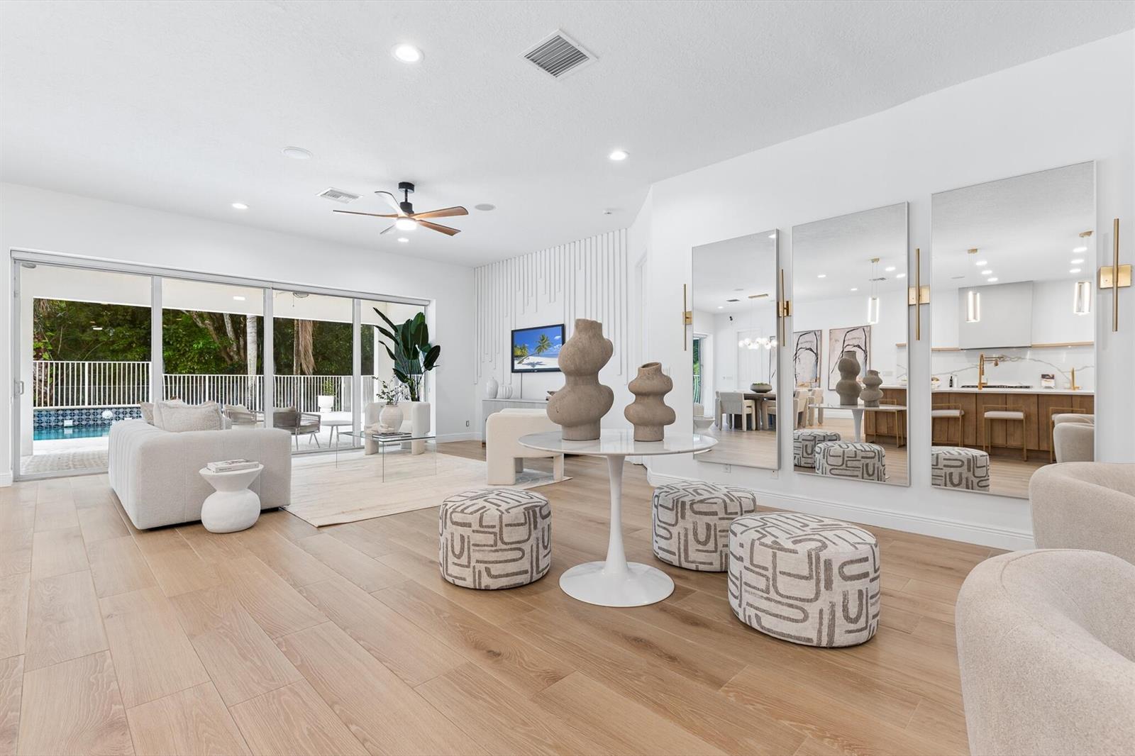 A modern kitchen features white cabinets, a wood-toned island with a gold faucet, and stainless appliances — 8717 Estate Drive, West Palm Beach FL 33411, WEST PALM BEACH, FL