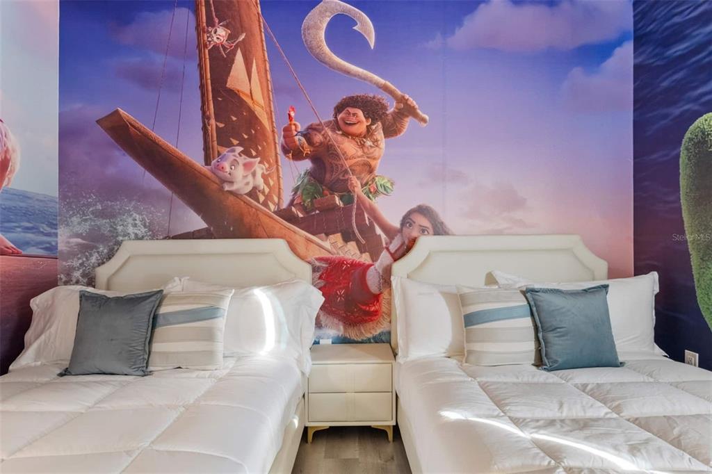 A bedroom features two beds with white bedding and a large Moana-themed wall mural — 4041 SONOMA BOULEVARD, KISSIMMEE, FL