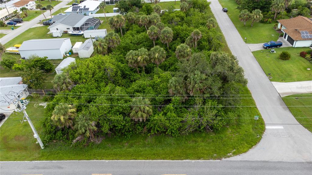 An aerial view shows a vacant, heavily wooded residential lot situated between two paved streets — 18390 OHARA DRIVE, PORT CHARLOTTE, FL