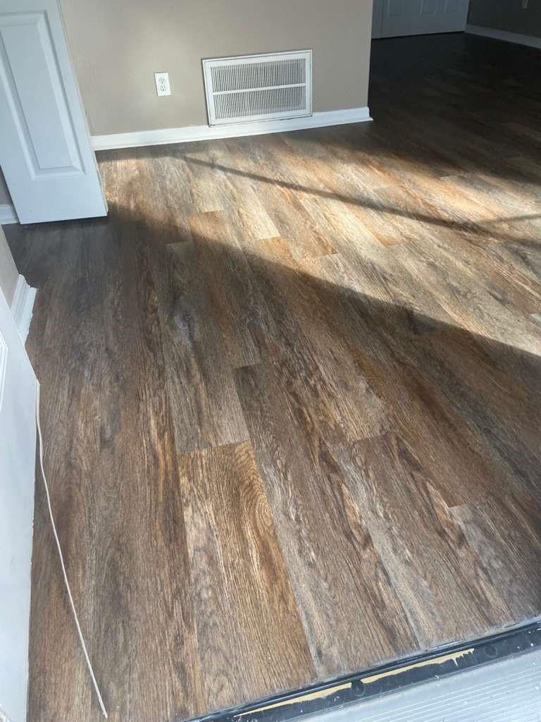 A room with dark wood-look vinyl plank flooring, a white door, and a wall vent — 1801 SE 40th Street Road, Ocala FL 34480, OCALA, FL