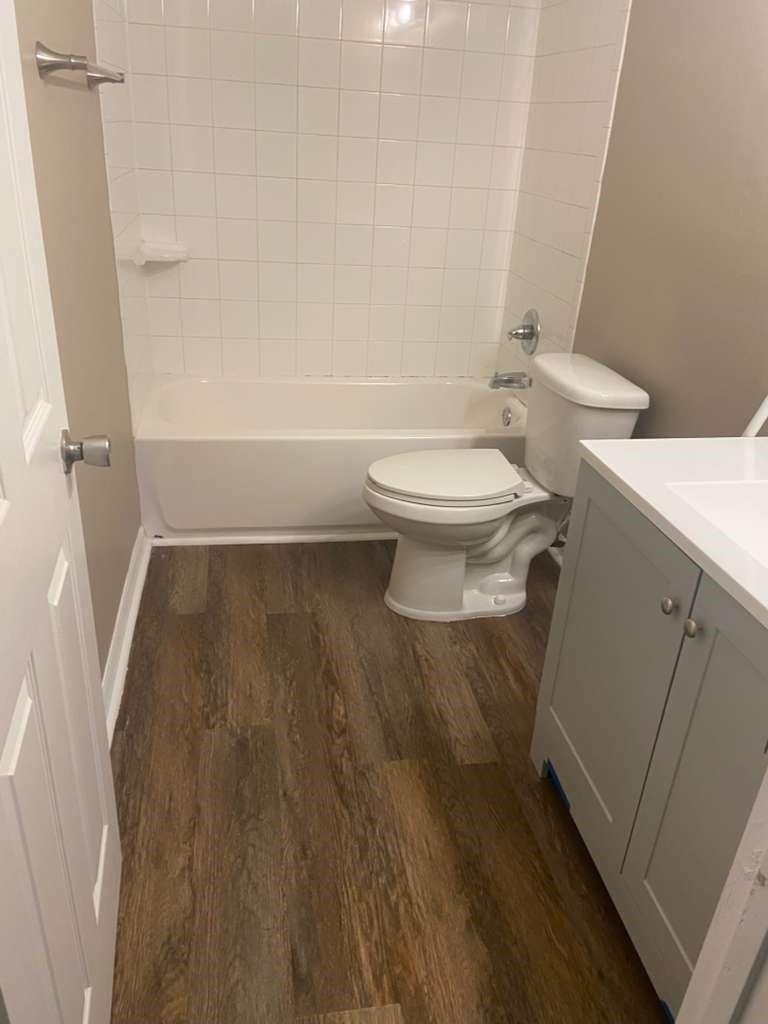 A bathroom features a white tub with tiled walls, a toilet, and a grey vanity — 1801 SE 40th Street Road, Ocala FL 34480, OCALA, FL