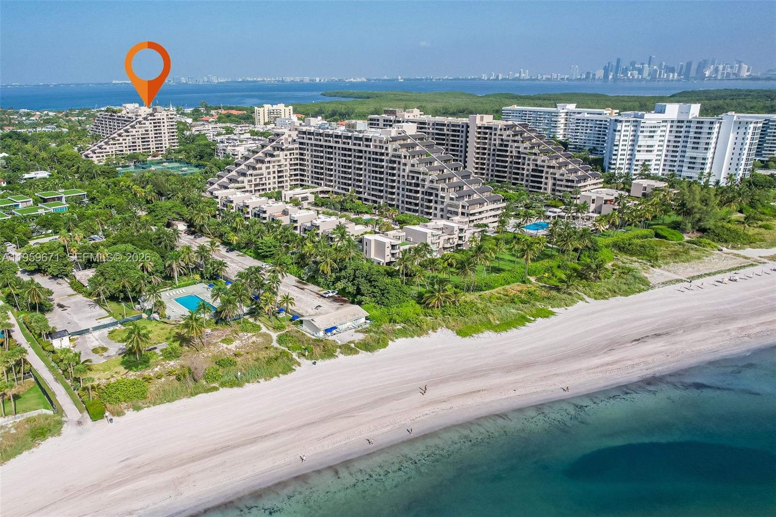 An aerial view shows a large beachfront residential complex with terraced buildings and swimming pools — 151 Crandon Blvd # 802, Key Biscayne FL 33149, KEY BISCAYNE, FL