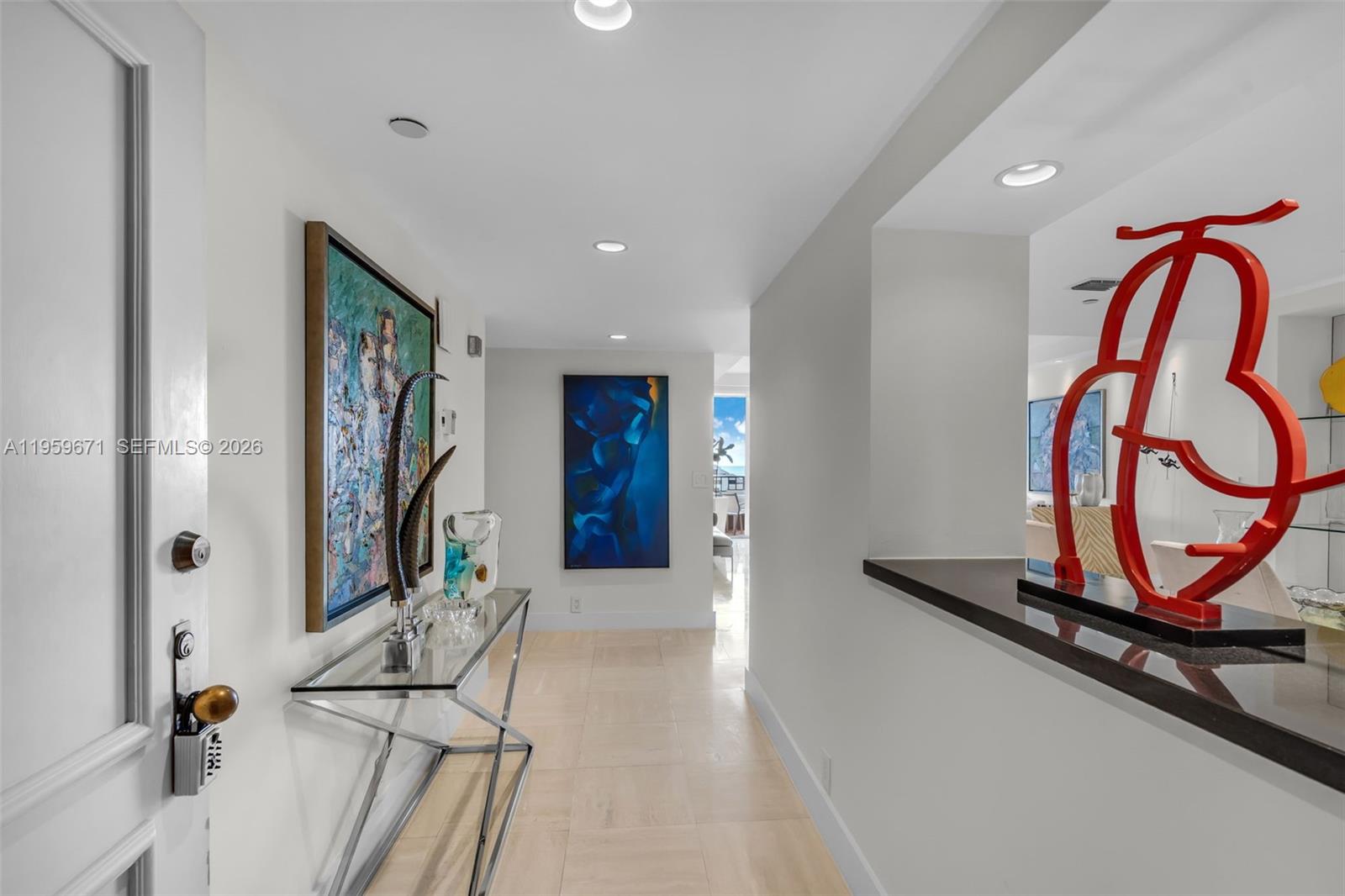 A bright hallway features light tile flooring, modern art, and a glass console table — 151 Crandon Blvd # 802, Key Biscayne FL 33149, KEY BISCAYNE, FL