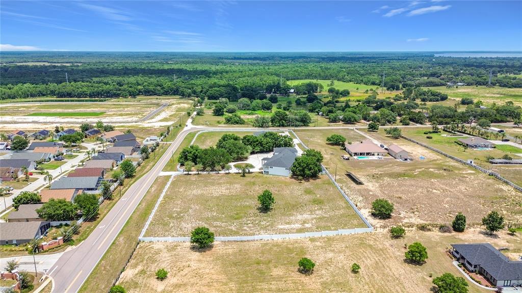 An aerial view shows a large residential lot with a house, pool, and white fencing — 7925 LAKE MABEL LOOP ROAD, DUNDEE, FL