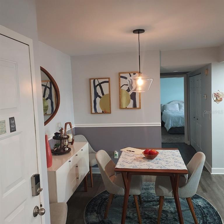 A dining area features a wooden table, chairs, a sideboard, and a pendant light — 4411 SHADY TERRACE LANE UNIT 209, TAMPA, FL