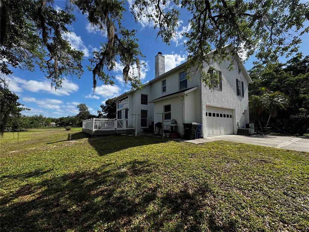 A two-story white house with a garage, a wooden deck, and a chimney — 1701 BERN CREEK LOOP, SARASOTA, FL