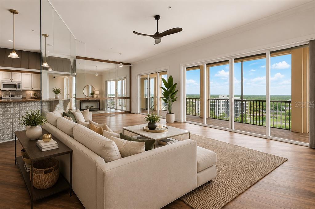 A living room with wood floors, a sectional sofa, and sliding doors opening to a balcony — 2060 MATECUMBE KEY ROAD UNIT 2803, PUNTA GORDA, FL