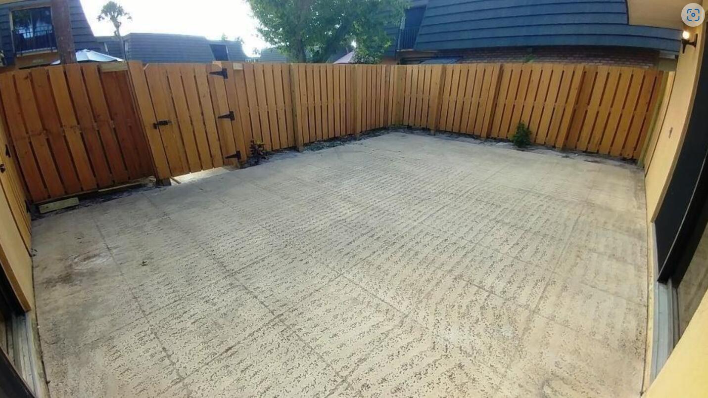 A concrete patio enclosed by a wooden privacy fence in a residential backyard — 221 2nd Way, West Palm Beach FL 33407, WEST PALM BEACH, FL