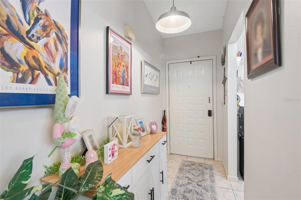 An entryway features a white console table, framed wall art, and a white front door — 8626 SHADBLOW COURT UNIT 1, PORT RICHEY, FL