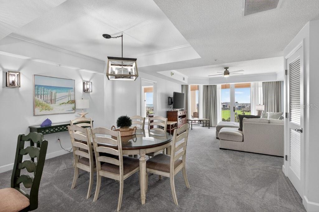 A dining area with a round table and chairs opens into a living room — 200 OCEAN CREST DRIVE UNIT 517, PALM COAST, FL